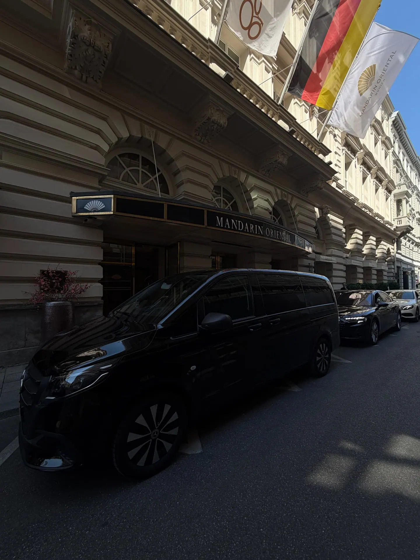 Schwarze Mercedes V-Klasse vor dem Mandarin Oriental München — Luxushotel-Vorfahrt